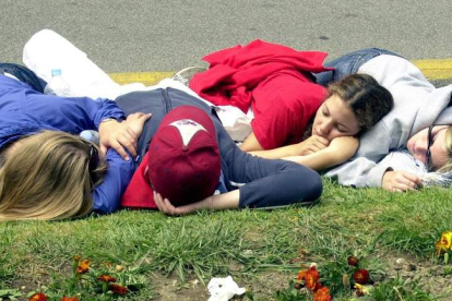 Cuatro jóvenes descansan en un parque en Pamplona durante san Fermín. IVÁN BENITEZ