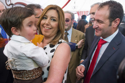Susana Díaz, con su hijo en brazos, acompañada por su marido en la Feria de Abril. RAÚL CARO