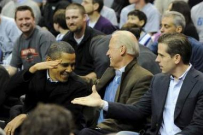 Obama saluda al vicepresidente Joe Biden, en el centro, y a su hijo Hunter en un partido.
