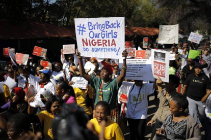 Un grupo de activistas muestra pancartas en las que se puede leer "traer de vuelta a nuestras niñas" en Johannesburgo