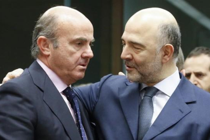 El ministro Luis de Guindos conversa con el comisario de Asuntos Economicos, Pierre Moscovici, en Bruselas el 14 de enero.