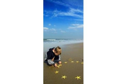 Un niño hace con estrellas de mar la bandera de la Unión Europea