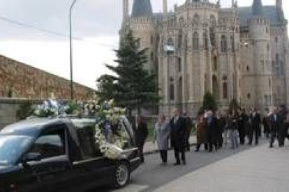 El coche fúnebre con los restos del escritor es seguido por la comitiva cerca del Palacio Episcopal