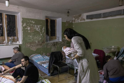 Una madre acuna a su hijo recién nacido en una maternidad de Kiev. ROMAN PILIPEY