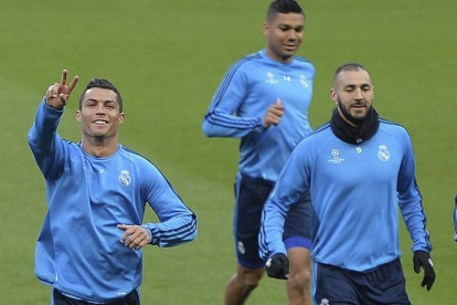 Cristiano, junto a Benzema, hace el gesto de la victoria en el campo del Manchester. POWELL