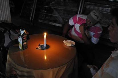 Hombres sentados en una panadería en San Cristóbal, a 600 kilómetros al oeste de Caracas, el 25 de abril.