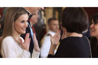 Doña Letizia habla en lengua de signos con una invitada durante la recepción a los representantes instucionales en el Palacio Real con motivo de la proclamación del rey