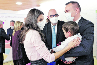 Letizia, en marzo del año pasado, acaricia a Marco en presencia de su padre, en el acto del Día Mundial de las Enfermedades Raras que se celebró en León. RAMIRO