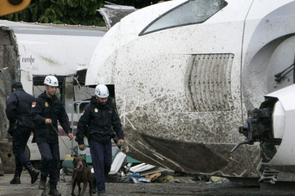 Agentes de la Policía Científica ayudados de perros prosiguen las investigaciones del tren.