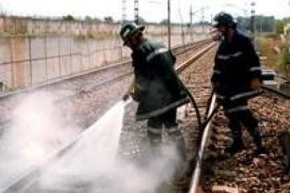 Imagen de archivo en la que los bomberos apagan un fuego en la vía