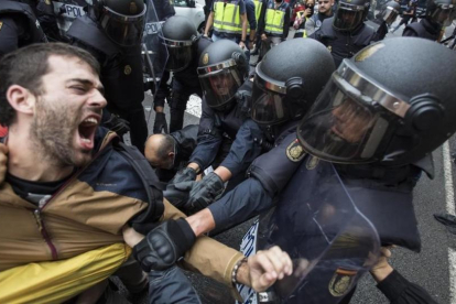La policia nacional intenta desalojar a las personas concentradas en las puertas del colegio electoral Ramon Llull de Barcelona el 1-O.