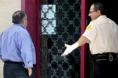 Un hombre solicita información a un vigilante de la sede central de Cajasur en Córdoba.
