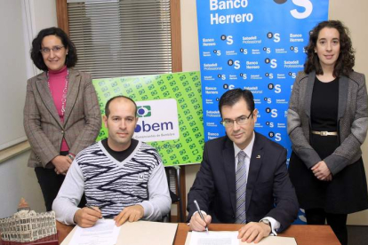 Representantes de la asociación de comerciantes y del Banco Herrero durante la firma del acuerdo.