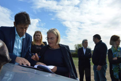 El secretario municipal formaliza la expropiación del suelo con una de las dueñas, ante la mirada de Oláiz.