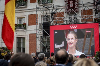 Decenas de personas siguen en una pantalla gigante instalada en la Real Casa de Correos, sede del Gobierno de la Comunidad de Madrid, la ceremonia de jura de la Constitución de Leonor de Borbón. EFE/ FERNANDO VILLAR