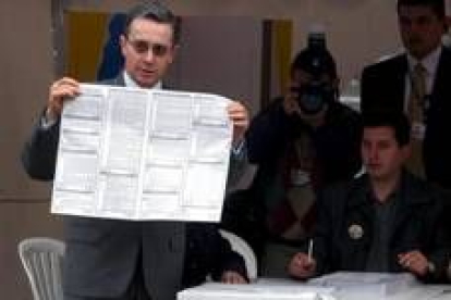 El presidente colombiano, Álvaro Uribe, sostiene la papeleta con su voto, ayer en Bogotá