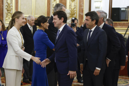 La princesa Leonor (2i), junto a la infanta Sofía (i), la reina Letizia (3i), y el rey Felipe VI (2d), saluda al presidente de la Junta de Castilla y León, Alfonso Fernández Mañueco (d), en el Salón del Trono del Palacio Real, durante el saludo a los invitados al almuerzo. EFE/JUANJO MARTÍN