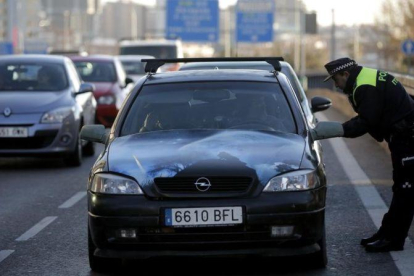 Un agente exige a un conductor con matrícula acababa en cero que dé media vuelta y no entre en Madrid, este jueves en la avenida de América.