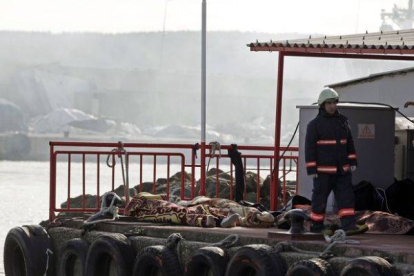 Un agente turco de Salvamento custodia los cuerpos de varias víctimas del naufragio.