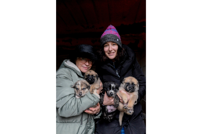 Choni Pardo Llaneza y Mery Monterde Durán con los últimos cuatro cachorros de la familia de nonillizos que recogieron hace dos semanas y ya tienen todos nuevo hogar. MARÍA FUENTES