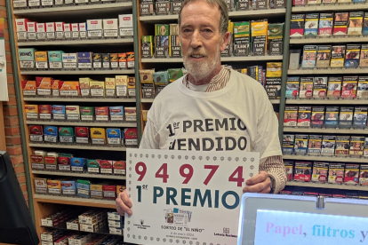 Máximo González, con el cartel del primer premio de la lotería de El Niño, parte del cual ha caído en León. P. I.