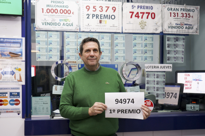 El gerente de la administración de loterías número 4 de Plasencia, Antonio Merino, muestra el número agraciado con el primer premio del sorteo de 
