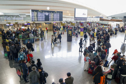 Largas colas de viajeros este sábado en la terminal del aeropuerto de Bilbao. LUIS TEJIDO