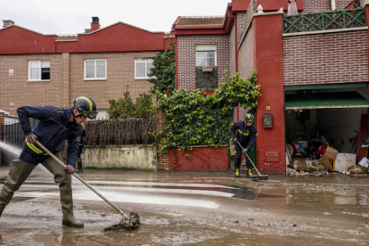 Bomberos limpian una zona afectada por el desbordamiento del río Cega en Viana de Cega (Valladolid) este lunes. NACHO GALLEGO