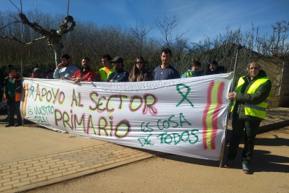 Varios agricultores exhiben una pancarta durante la visita de Gerardo Dueñas a Jiménez de Jamuz.