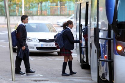 Estudiantes se suben a una autobús escolar.