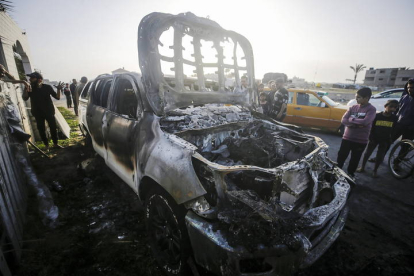 La gente observa el automóvil destruido de la ONG World Central Kitchen (WCK) a lo largo de la carretera Al Rashid, entre Deir Al Balah y Khan Younis en el sur de la Franja de Gaza, el martes.