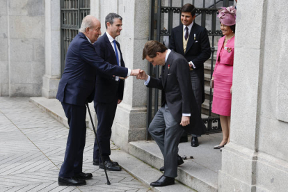 El alcalde de Madrid, José Luis Martínez-Almeida (d), saluda al rey emérito Juan Carlos I este sábado a las puertas de la iglesia de San Francisco de Borja de Madrid antes de contraer matrimonio con Teresa Urquijo.