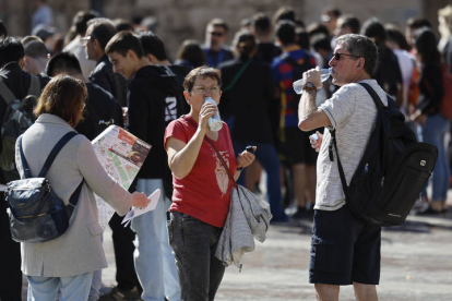 Varios turistas se hidratan este jueves ante la llegada del calor.