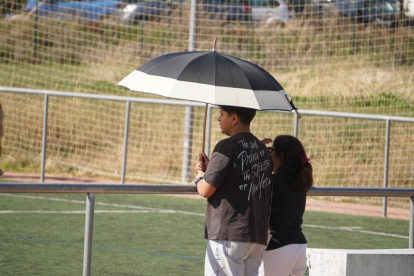 Dos personas se protegen del sol con un paraguas.