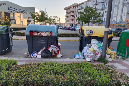 Contenedores a reventar en San Andrés del Rabanedo con los residuos desparramados por el suelo.