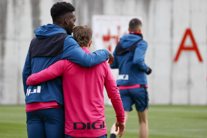 El delantero del Athletic Club Iker Muniain recibe el abrazo de su compañero Iñaki Williams (i) durante el entrenamiento realizado este miércoles en las instalaciones de Lezama. Muniain ha comunicado al club que, 