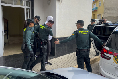 Agentes de la Guardia Civil trasladan a uno de los dos detenidos por el asesinato de una vecina de 65 años del municipio valenciano de Rafelcofer, profesora jubilada.