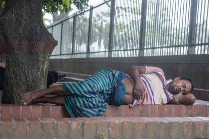 Un hombre duerme en Dhaka.