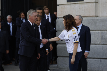 El entrenador del Real Madrid Carlo Ancelotti saluda a la presidenta de la Comunidad de Madrid, Isabel Díaz Ayuso, tras la visita del equipo a la Real Casa de Correos durante los actos de celebración de la trigésimo sexta Liga conseguida por el club. EFE/Mariscal