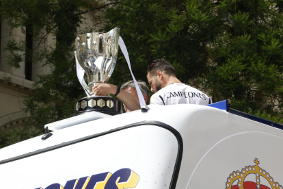 El capitán del Real Madrid Nacho Fernández (d) junto al trofeo en el autobús antes de dirigirse a Cibeles tras la recepción que ha tenido lugar en ayuntamiento de la capital como parte de los actos de celebración de la trigésimo sexta Liga conseguida por el equipo. EFE/Zipi Aragón