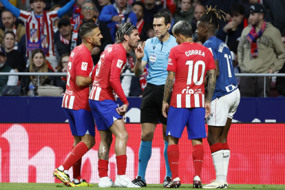Jugadores del Atlético de Madrid conversan con el árbitro Martínez Munuera durante un partido de la Liga española. EFE/Mariscal