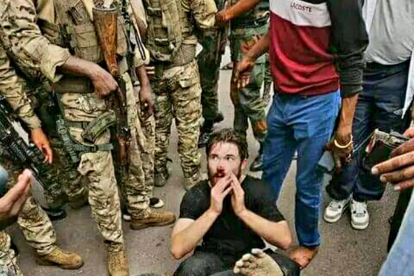 Uno de los civiles implicado en el golpe de estado del Congo antes de ser detenido y en el momento de realizar el asalto a la vivienda presidencial.