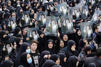 Mujeres iraníes vestidas con chadores negros sostienen carteles del difunto presidente iraní Ebrahim Raisi mientras participan en una ceremonia de luto en Teherán, Irán, el 20 de mayo de 2024.EFE/ Abedin Taherkenareh