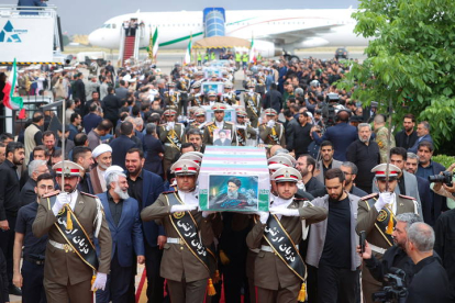 A handout photo made available by the Iranian Presidential Office shows Iranian soldiers carrying the coffins of late president Ebrahim Rais
