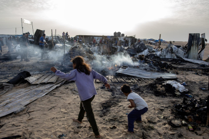 Palestinos entre los daños en un campo de desplazados de Rafah atacado por Israel este 27 de mayo. EFE/EPA/HAITHAM IMAD