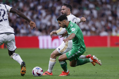 El defensa del Real Madrid Dani Carvajal (detrás) lucha con Ayoze Pérez, del Betis, durante el partido de la jornada 38 de LaLiga que Real Madrid y Real Betis disputaron en el estadio Santiago Bernabéu, en Madrid. EFE/Javier Lizón