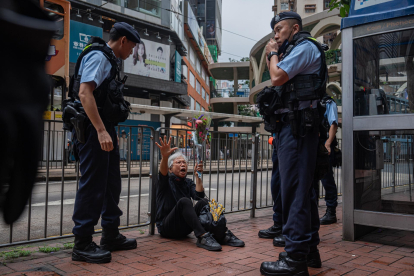 Alexandra Wong (C), una activista conocida como Abuela Wong, se sienta en el suelo antes de ser detenida por agentes de policía en Causeway Bay, cerca de Victoria Park en Hong Kong, el 4 de junio de 2024. Durante más de tres décadas, miles de personas se congregaban en el emblemático Parque Victoria de Hong Kong para conmemorar, de forma pacífica y a la luz de las velas, a las víctimas de la represión, una tradición que se celebró por última vez en 2019 y que ahora ha sido reemplazada por un "carnaval" organizado por grupos pro-Pekín. EFE/EPA/LEUNG MAN HEI