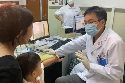El Dr. Yilai Shu se comunica con un joven paciente en el Hospital Oftalmológico y Otorrinolaringológico de la Universidad de Fudan, en Shanghai (China). Crédito: Hospital Oftalmológico y Otorrinolaringológico de la Universidad de Fudan, Shanghai, China