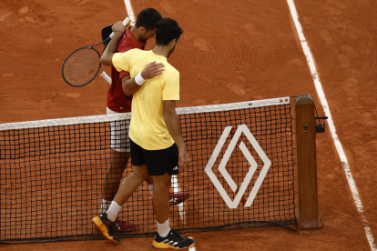 El serbio Novak Djokovic de Serbia (i) se abraza con el argentino Francisco Cerundolo de Argentina tras ganar su partido en Roland Garros, en París, Francia. EFE/EPA/YOAN VALAT