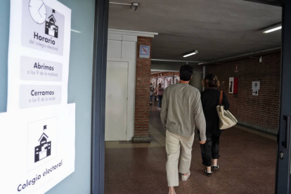 Dos personas entran en un colegio electoral en Valladolid para ejercer su voto en las elecciones del parlamento europeo.